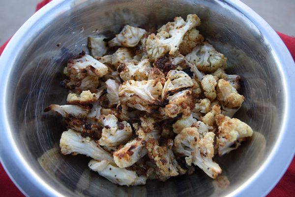 Roasted cauliflower florets in a metal bowl